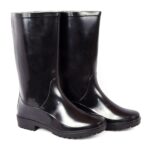 A pair of Dreamer safety gumboot. The shiny, black rubber safetygumboot rain boots with a simple design. The boots have a sturdy and flat sole with a modest tread pattern for grip. They reach mid-calf in height and are positioned side by side, with slight reflections visible on their surface.