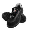 A pair of black athletic Nexon Safety Footwear from Agarson Safety Shoe with a knit mesh upper and synthetic overlays, featuring a lace-up design and a cushioned sole with a rugged tread pattern. The interior has a gray fabric lining, and there are small reflective details near the heel and sides.